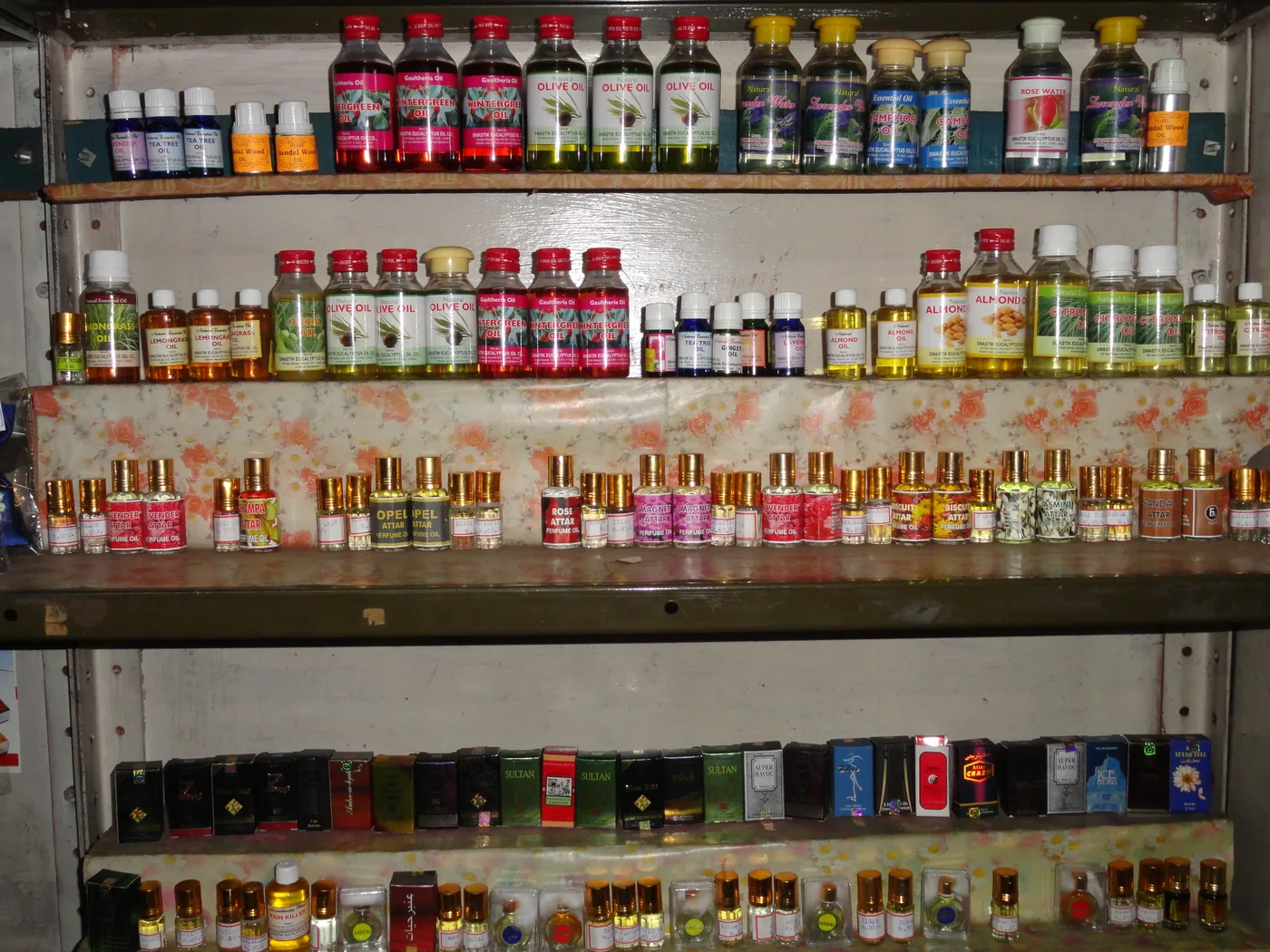 商店货架上陈列的多款香水瓶,用于说明瓶型、泵头与标签版本的分层