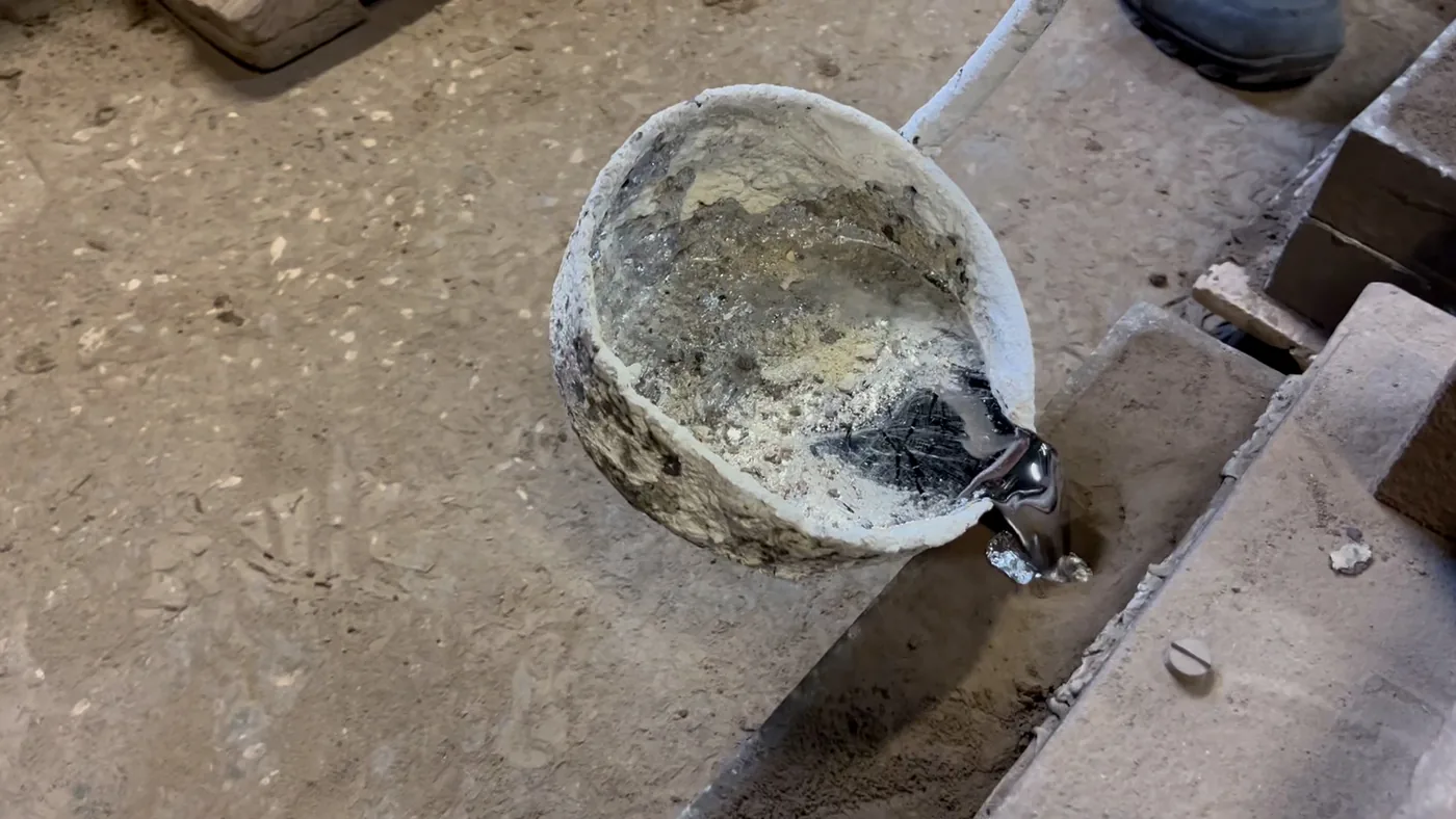 铸造车间内坩埚熔化金属并进行浇注,用于说明砂型与熔模铸造的浇注环节